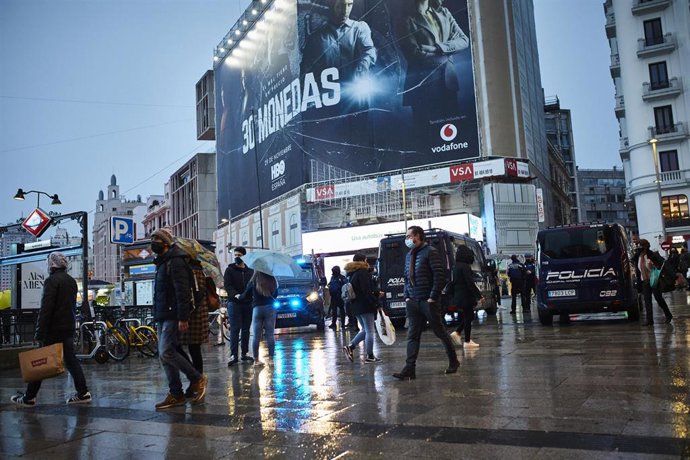 Archivo - Transeúntes caminan cerca de una zona comercial en la calle de Preciados, en Madrid (España), a 27 de noviembre de 2020. La ciudad de Madrid estrena este viernes el dispositivo policial de Navidad que da comienzo con la campaña comercial del B