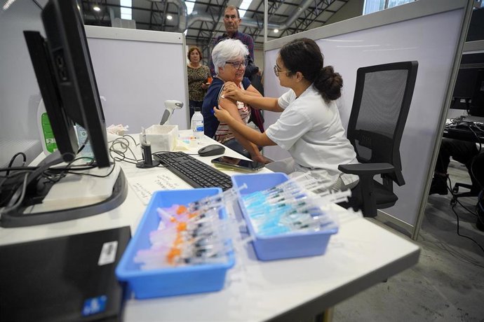 Archivo - Una mujer se vacuna contra la covid en Vigo.
