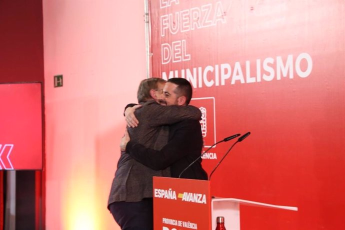 El secretario general del PSPV, Ximo Puig, y el secretario general del PSPV en la provincia de Valencia, Carlos Fernández Bielsa, se abrazan durante el acto 'La fuerza del municipalismo', este viernes en Valncia