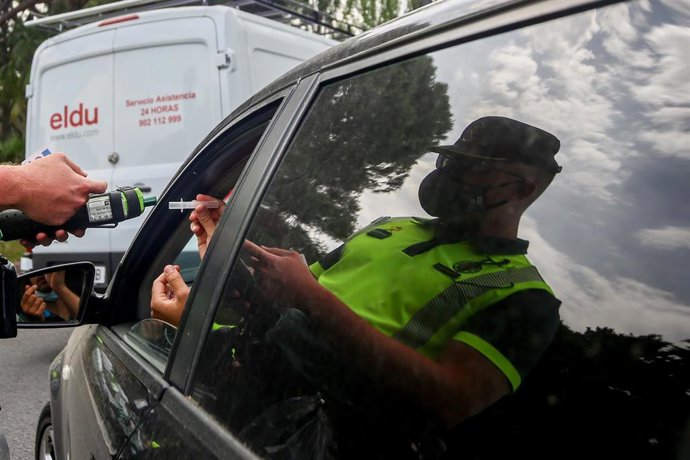 Archivo - Un policía para a los coches para someter a pruebas de control de consumo de drogas y alcohol a los conductores