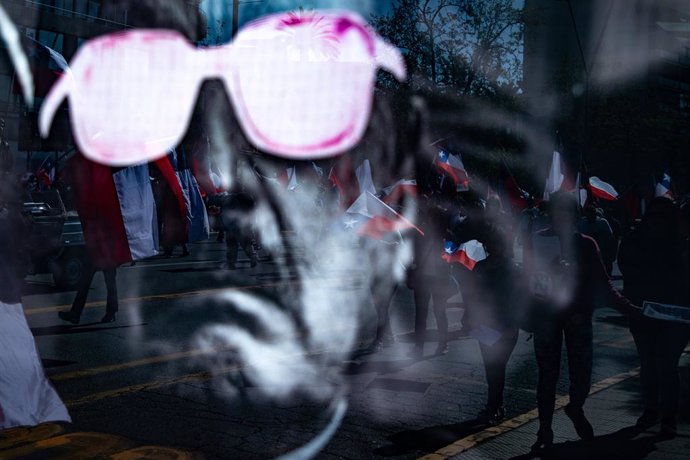 Archivo - September 30, 2023, Santiago, Metropolitan Region, Chile: A group of supporters of the ultra-right movement Team Patriota March is reflected on an Augusto Pinochet Dictator Poster during a march against GABRIEL BORIC's President in Santiago, Chi