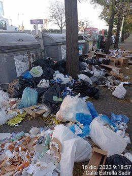 Basura acumulada en la acera, fuera de los contenedores, en una de las zonas de la ciudad de Sevilla que han amanecido con residuos esparcidos por el suelo.