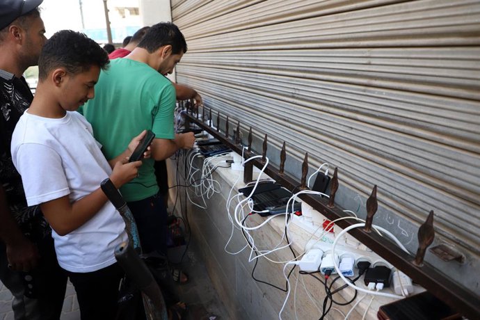 Archivo - GAZA, Oct. 18, 2023  -- Palestinians charge phones from one power source in the southern Gaza Strip city of Khan Younis, on Oct. 18, 2023. The Palestinian Islamic Resistance Movement (Hamas) on Oct. 7 showered Israel with thousands of rockets 