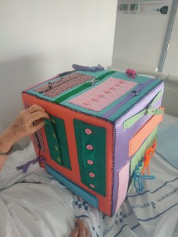 Cubo realizado por las costureras del HUC que, ante la solicitud de un terapeuta, elaboraron una herramienta para ejercitar las herramientas del vestido.