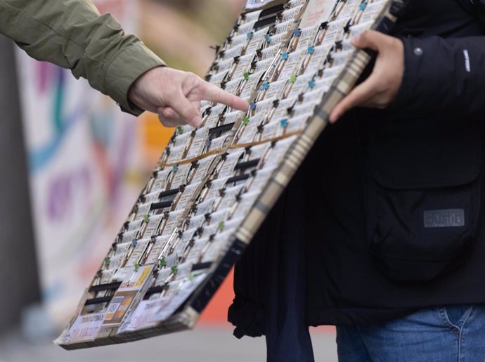 Una persona elige un décimo de la administración de lotería Doña Manolita de cara al Sorteo Extraordinario de la Lotería de Navidad, a 14 de diciembre de 2023, en Madrid (España). 