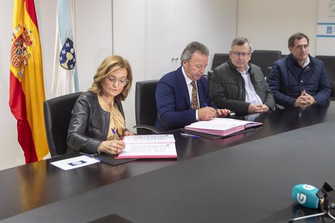 La conselleira de Promoción do Emprego e Igualdade, Elena Rivo, y el presidente de la Federación de Autónomos do Taxi de Galicia (Fegataxi), Manuel Sánchez Quindimil, firman un acuerdo para el desplazamiento de víctimas de violencia de género.