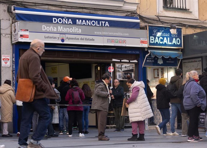 Varias personas hacen cola para comprar décimos de cara al Sorteo Extraordinario de la Lotería de Navidad, en la Administración de Loterías Doña Manolita, a 14 de diciembre de 2023, en Madrid (España). 
