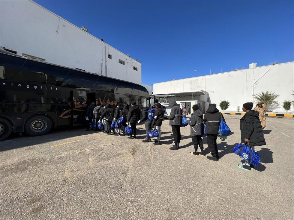 Migrantes hacen cola en un centro de deportación en Trípoli, Libia
