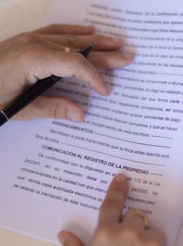 Archivo - Una mujer con un bolígrafo, señala una escritura de compraventa de una hipoteca, a 30 de mayo de 2022, en Madrid (España). 
