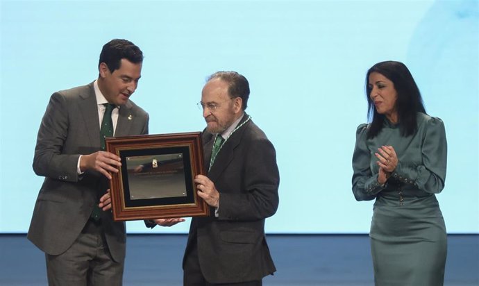 Archivo - El presidente de la Junta de Andalucía Juanma Moreno (i), junto a la presidenta del Parlamento de Andalucía, Marta Bosquet (d), otorga la mención de Hijo Predilecto al periodista y escritor Antonio Burgos (c). (Foto de archivo).