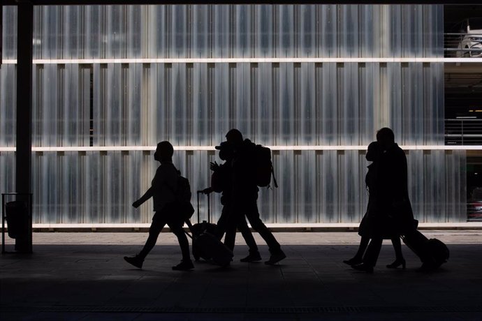 Archivo - Varias personas caminan con su equipaje en el Aeropuerto de Barcelona-El Prat