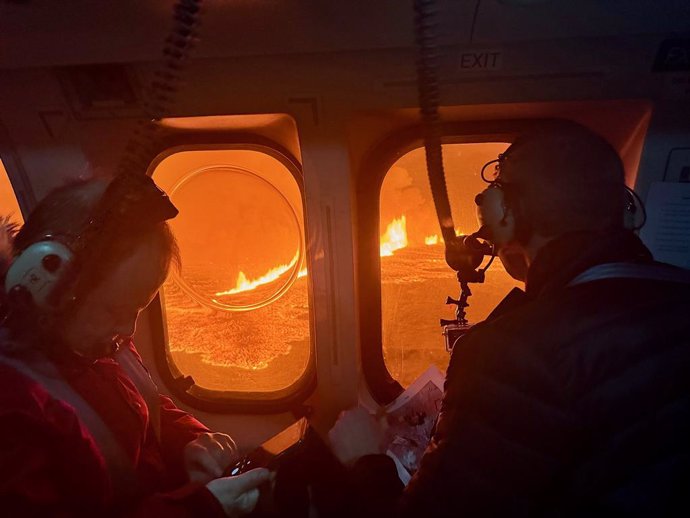 December 19, 2023, Grindavik, Western Iceland, Iceland: Icelandic Coast Guard personnel watch volcanic magma flows on a hill near Grindavik on Iceland's Reykjanes Peninsula. A volcanic eruption started Monday night on Iceland's Reykjanes Peninsula, follow