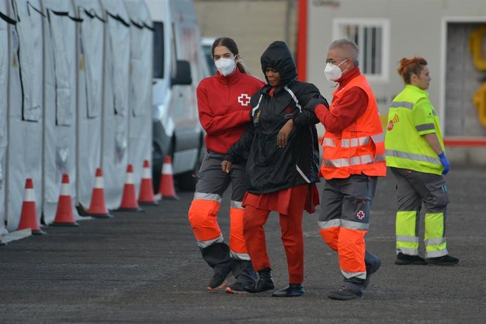Trabajadores de la Cruz Roja ayudan a una de las integrantes de una patera que ha llegado al Muelle de La Restinga en la isla de El Hierro