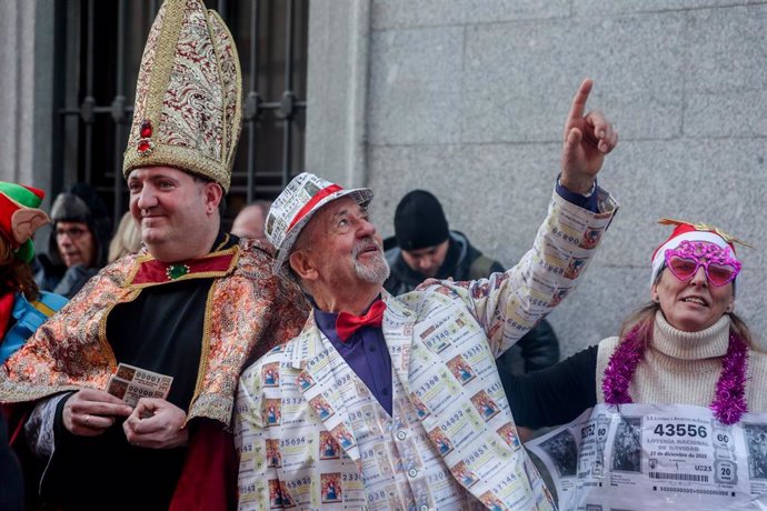 Varias personas disfrazas de décimos de lotería un día antes del Sorteo Extraordinario de la Lotería de Navidad, en el Teatro Real, a 21 de diciembre de 2023, en Madrid (España). 