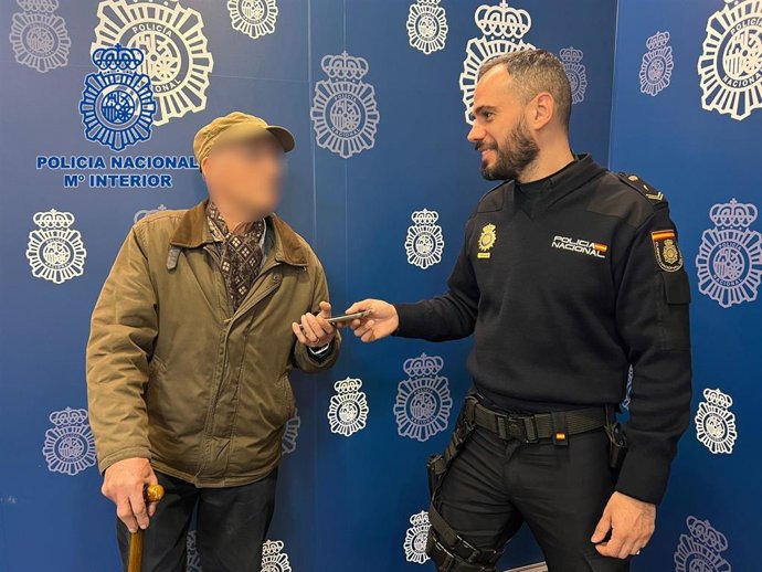 Entrega de un teléfono a uno de los ancianos víctimas de la estafa