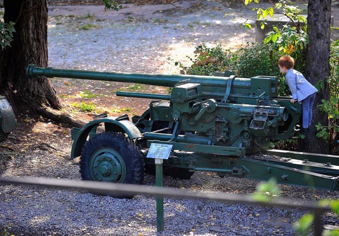 Archivo - Sept. 26, 2012 - Sarajevo, Bosnia and Herzegovina - A little boy plays with a M37 - 75 mm Skoda ant-aircraft used during the second war.