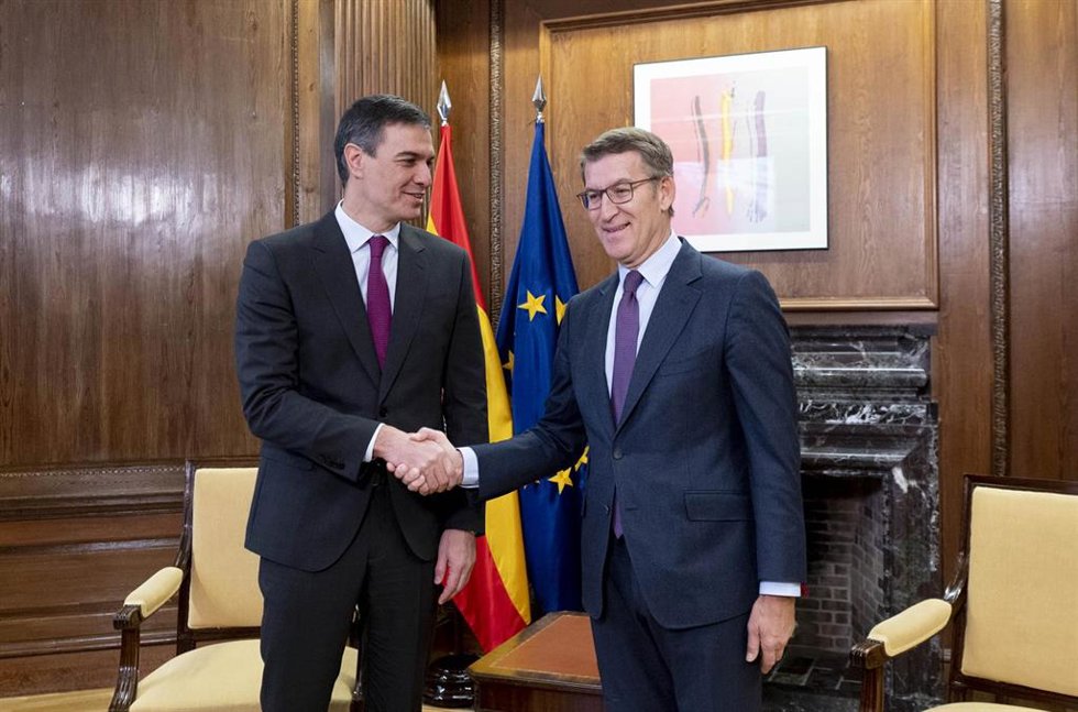 El presidente del Gobierno, Pedro Sánchez (i), y el líder del PP, Alberto Núñez Feijóo (d), se saludan durante la reunión