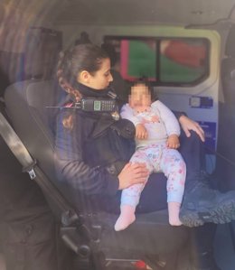 Una agente de Policía Local con el bebé.