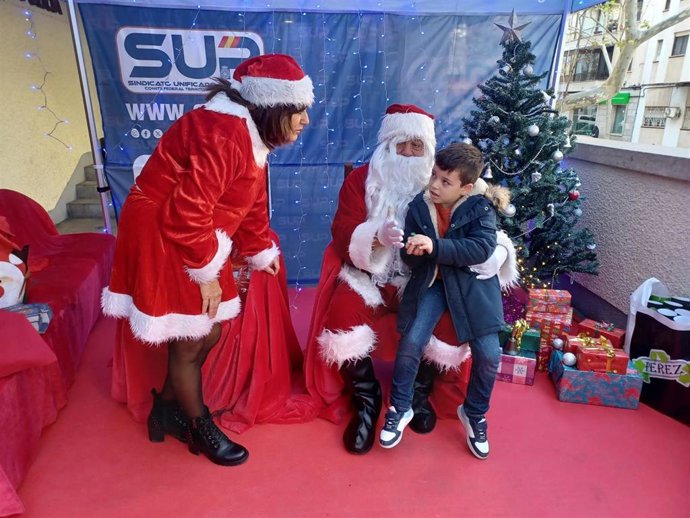 Papa Noel con uno de los niños en la Comisaría.