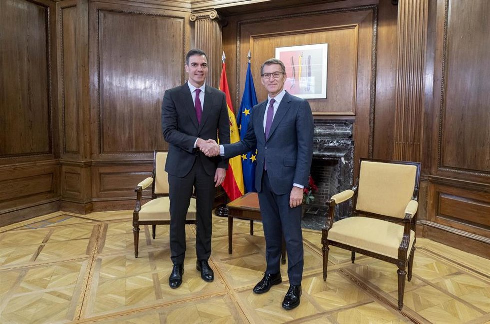 El presidente del Gobierno, Pedro Sánchez (i), y el líder del PP, Alberto Núñez Feijóo (d), se saludan durante una reunión, en el Congreso de los Diputados, a 22 de diciembre de 2023, en Madrid (España). 