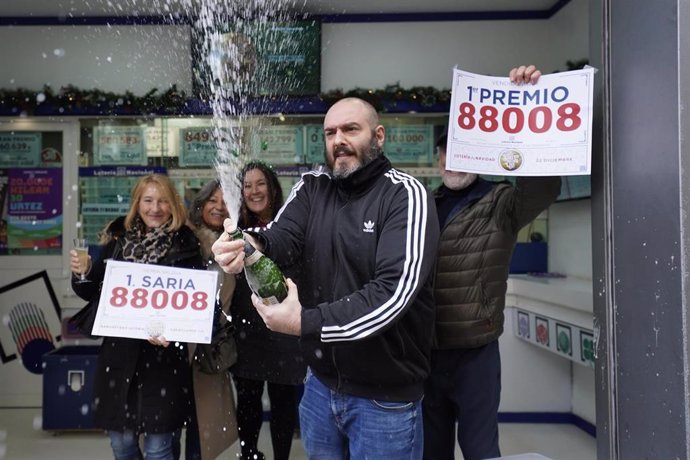 Agraciados con el Primer Premio del Sorteo Extraordinario de Lotería de Navidad 2023 correspondiente al número 88008 celebran su suerte en la administración donde compraron sus décimos, a 22 de diciembre de 2023, en Bilbao 