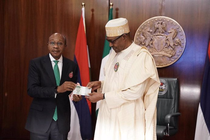 Archivo - El ex gobernador del Banco Central de Nigeria Godwin Emefiele, con el rediseño de la naira, a la izquierda 