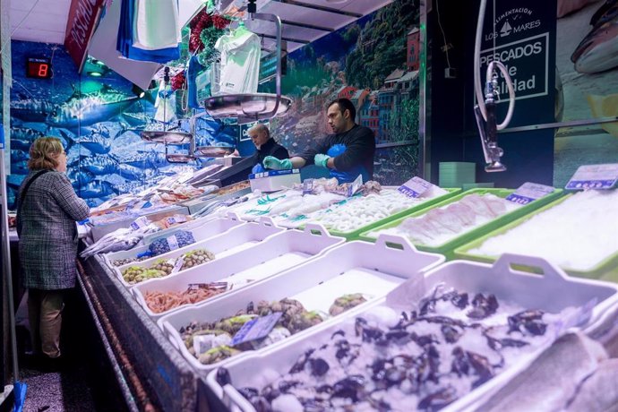 Archivo - Una mujer realiza sus últimas compras de pescado y marisco en la tienda de comestibles ‘Los Mares Alimentación’, en el barrio de Prosperidad, a 24 de diciembre de 2022, en Madrid (España). 