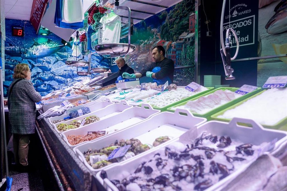 Archivo - Una mujer realiza sus últimas compras de pescado y marisco en la tienda de comestibles Los Mares Alimentación, en el barrio de Prosperidad, a 24 de diciembre de 2022, en Madrid (España).
