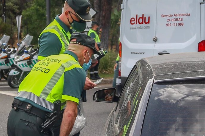 Archivo - Varios policías paran a los coches para someter a pruebas de control de consumo de drogas y alcohol.