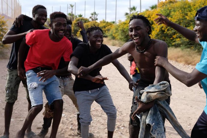 Archivo - Imagen de archivo, de junio de 2022, de migrantes celebrando el salto de la valla de Melilla.