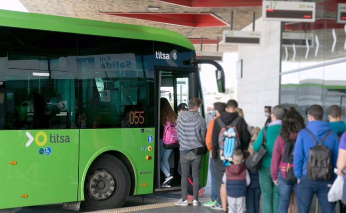 Archivo - Un grupo de personas hace cola para acceder a una guagua en el Intercambiador de La Laguna