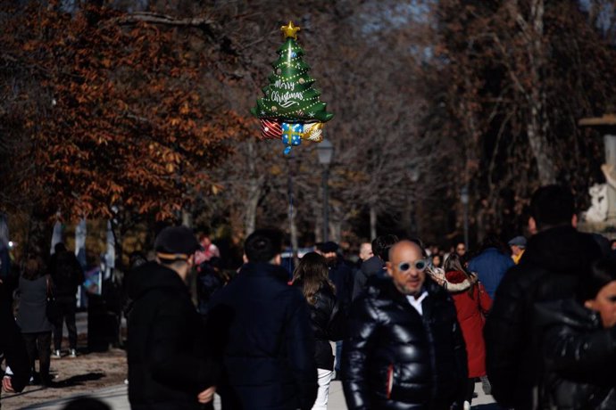 Niños juegan con sus regalos de Navidad al aire libre, en el Parque del Retiro, en Madrid (España)