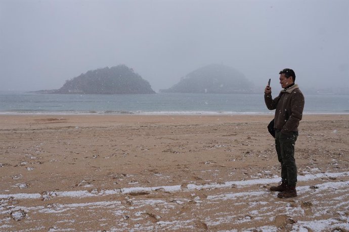Archivo - Un hombre fotografía la playa de Ondarreta, a 27 de febrero de 2023, en San Sebastián, Gipuzkoa, País Vasco (España).  