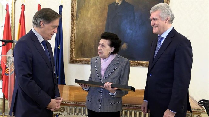 La hija de Cástor Iglésias, María Isabel Iglesias (c), entrega la batuta del director de la Banda Municipal de Música de Salamanca al alcalde de la ciudad, Carlos García Carbayo (i), en presencia del nieto del músico