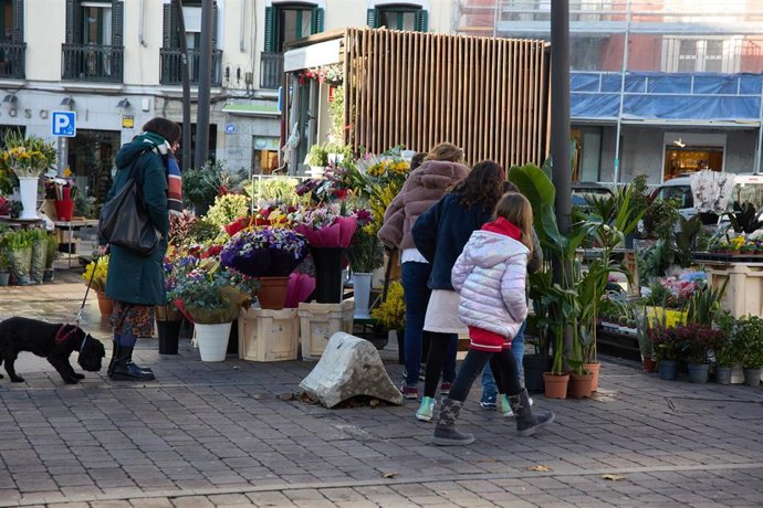 Archivo - Un mujer compra flores un puesto en la plaza de Tirso de Molina, a 14 de enero de 2023, en Madrid (España). a 14 de enero de 2023, en Madrid (España). 