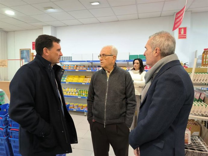 El presidente del Puerto de Huelva, Alberto Santana (izquierda), durante su visita al Economato Social Resurgir.