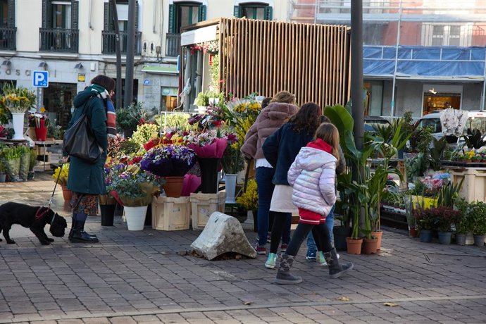 Archivo - Un mujer compra flores un puesto en la plaza de Tirso de Molina, a 14 de enero de 2023, en Madrid (España). a 14 de enero de 2023, en Madrid (España). 