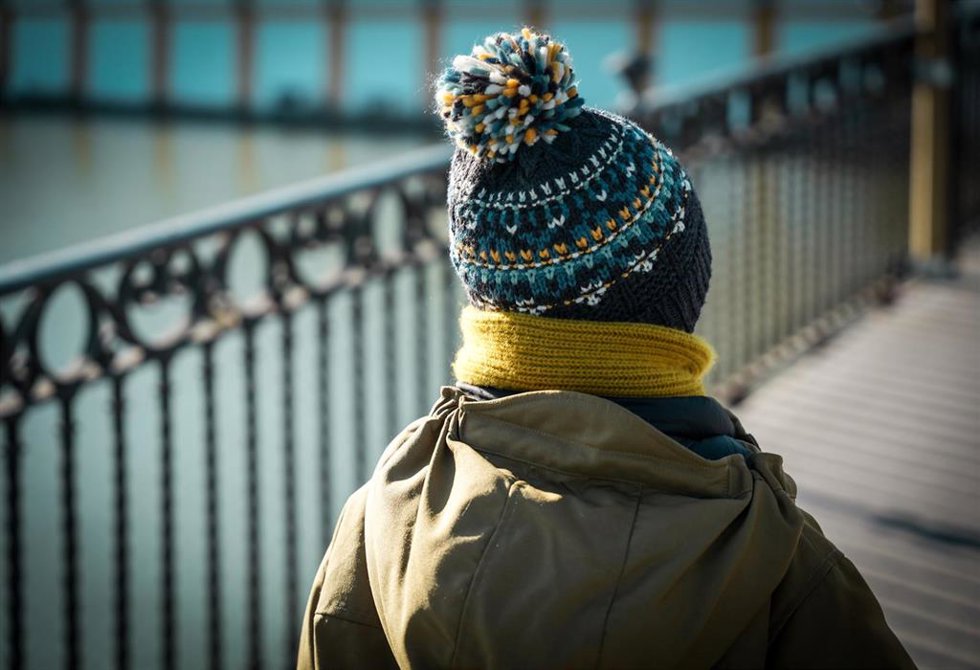 Un niño abrigado con gorro y bufanda