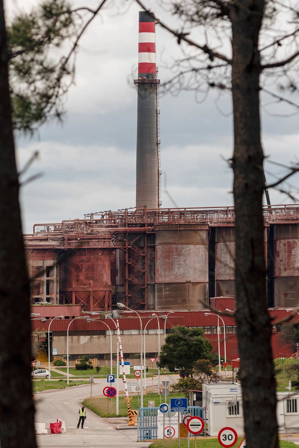Archivo - Un vigilante de seguridad en la entrada de la fábrica de Alcoa en San Cibrao, en Cervo (Lugo).