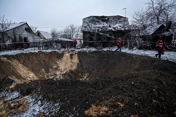 Un cráter visto cerca de una casa dañada como resultado de la explosión de un ataque con misiles por parte del Ejército ruso en Kiev