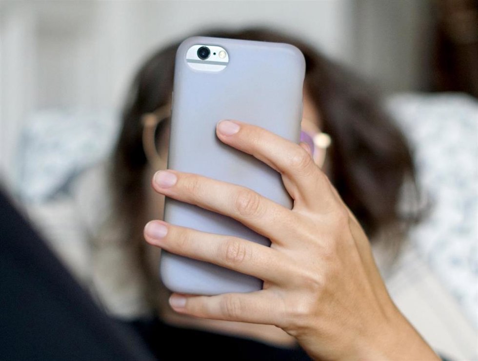 Archivo - Una persona con un teléfono móvil 