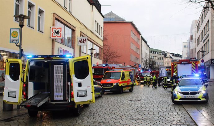 29 December 2023, Bavaria, Passau: Emergency services from the police, fire department and ambulance work at the scene in the city center after a truck has driven into a group of pedestrians in Passau city center, injuring several people and killing one w