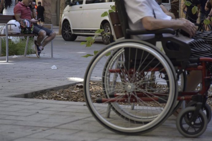 Archivo - Una persona en silla de ruedas en la calle Consell de Cent, a 8 de septiembre de 2023, en Barcelona, Catalunya (España).