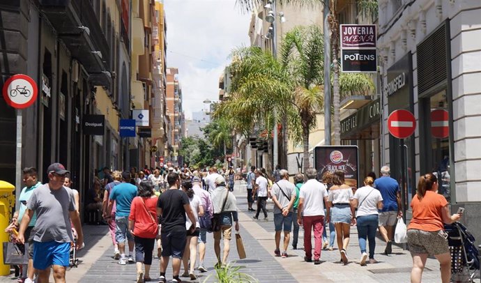 Archivo - Gente paseando por una calle comercial.