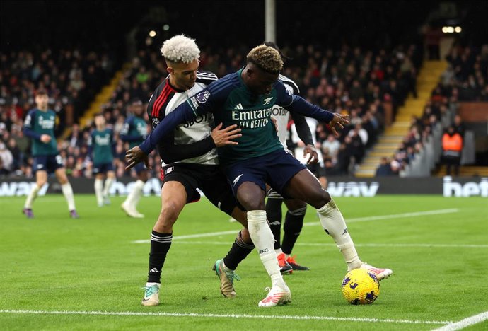 31 December 2023, United Kingdom, London: Fulham's Antonee Robinson (L) and Arsenal's Bukayo Saka battle for the ball during the English Premier League soccer match between Fulham and Arsenal at Craven Cottage. Photo: Steven Paston/PA Wire/dpa
