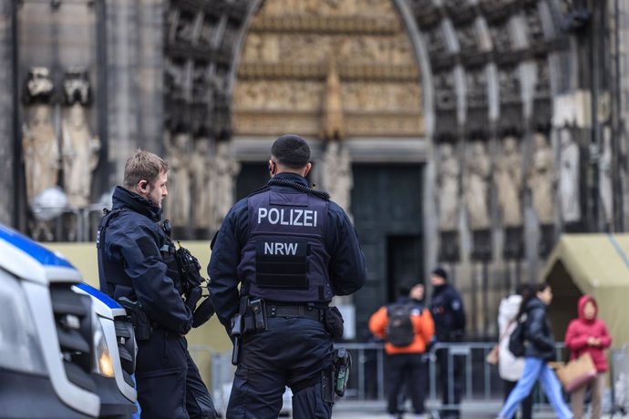 27 December 2023, North Rhine-Westphalia, Cologne: Police officers stand in front of the cathedral. Cologne Cathedral remains closed to visitors after the terror alert. Photo: Oliver Berg/dpa