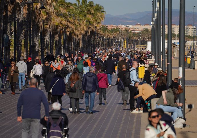 Varias personas pasean por el paseo marítimo, a 25 de diciembre de 2023, en Valencia, Comunidad Valenciana (España). Valencia ha amanecido con cielos despejados y, aunque las temperaturas máximas que se esperan, según la Agencia Estatal de Meteorología (A