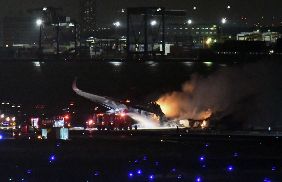 Bomberos trabajan en el accidente del avión de Japan Airlines en el aeropuerto de Tokio. 