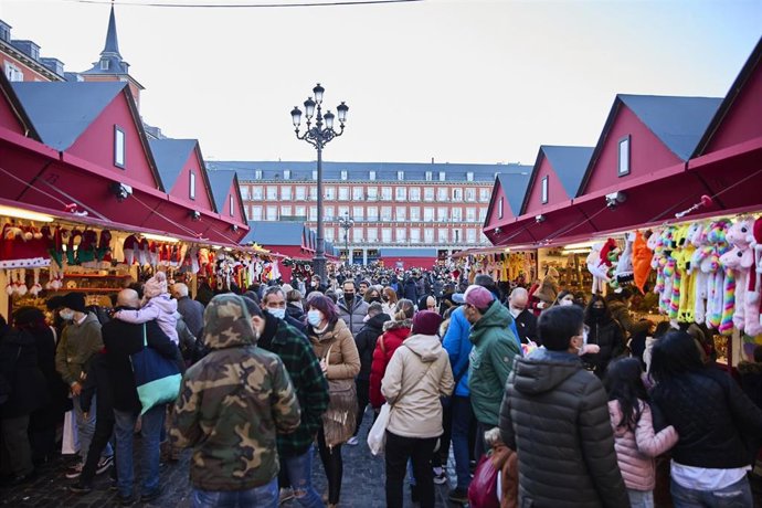Archivo - Un grupo de personas asiste al mercadillo navideño instalado en la madrileña plaza mayor, a 5 de diciembre de 2021
