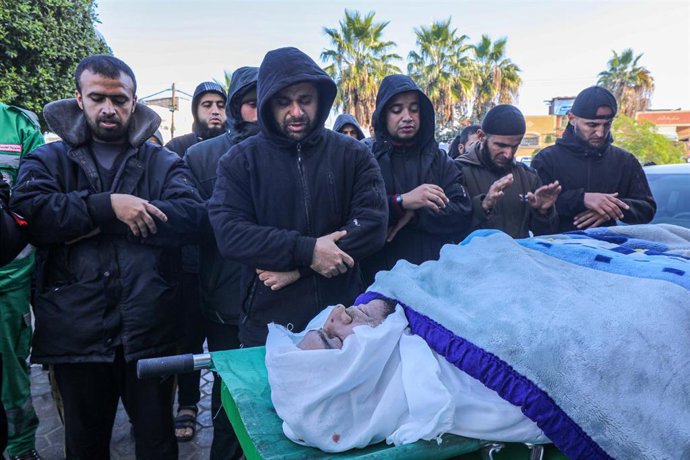 Un grupo de personas reza a sus seres queridos, muertos por ataques de Israel sobre Gaza.